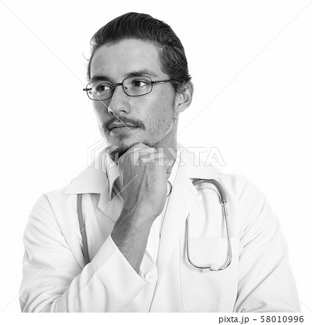 Close up of young handsome man doctor thinking while looking at distance with eyeglasses isolated Close up of young handsome man doctor thinking while looking at distance with eyeglasses isolated 58010996