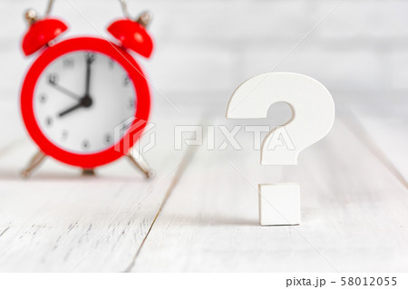 Question mark with alram clock on white wood table 58012055