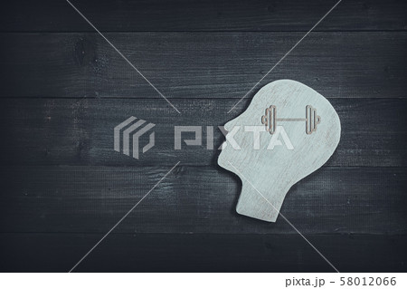 Human head and face with barbell sign on wood 58012066