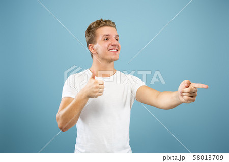 Caucasian young man's half-length portrait on blue background 58013709