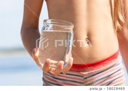 Jar with fresh river water in a child's hand on Jar with fresh river water in a child's hand on 58028469