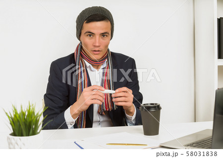 Asian man in a hat, scarf and jacket measure the Asian man in a hat, scarf and jacket measure the 58031838