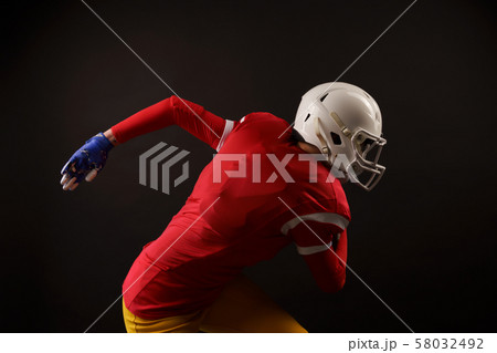 Picture of woman with rugby ball running to right, wearing helmet 58032492