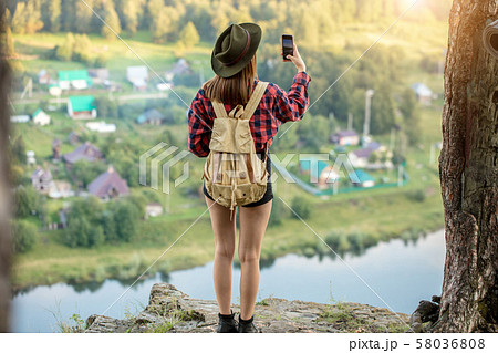 young ambitious girl taking photo, trying to catch wonderful moment 58036808