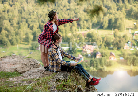 young pleasant girl pointing at the distance 58036971