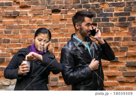 young man talking on the phone, girl misses and young man talking on the phone, girl misses and 58039309