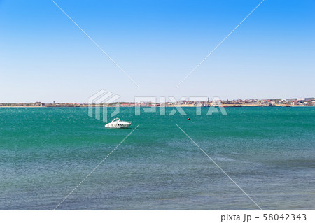 Vacation at sea background. White boat anchored in a turquoise water of sea bay. Sea coast with Vacation at sea background. White boat anchored in a turquoise water of sea bay. Sea coast with 58042343