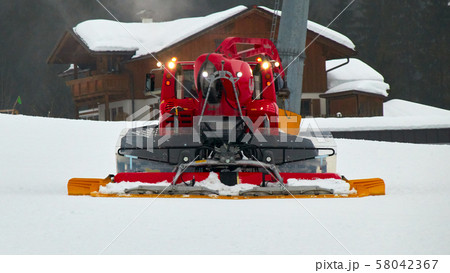 A red snowcat or snow groomer in action 58042367