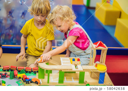 Children playing with wooden train. Toddler kid and baby play with blocks, trains and cars 58042638