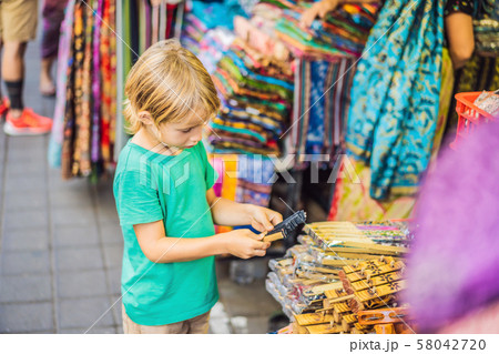 Boy at a market in Ubud, Bali. Typical souvenir shop selling souvenirs and handicrafts of Bali at 58042720
