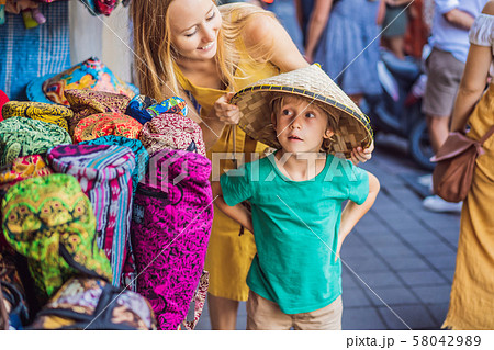 Mom and son travelers choose souvenirs in the market at Ubud in Bali, Indonesia 58042989