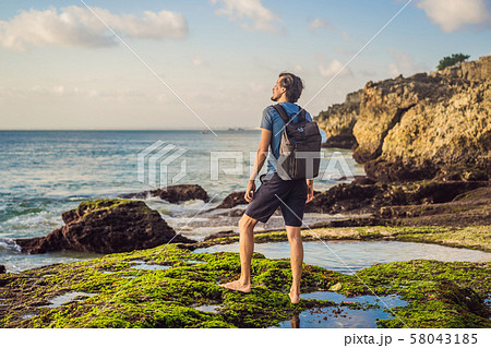 Young man tourist on Pantai Tegal Wangi Beach, Bali Island, Indonesia. Bali Travel Concept Young man tourist on Pantai Tegal Wangi Beach, Bali Island, Indonesia. Bali Travel Concept 58043185