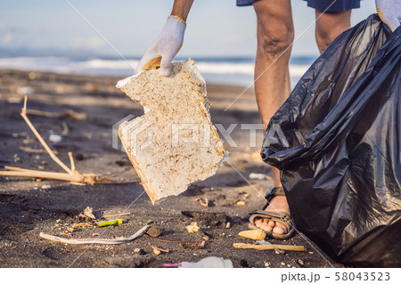 Young man cleaning up the beach. Natural education of children 58043523