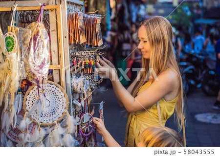 Mom and son travelers choose souvenirs in the market at Ubud in Bali, Indonesia 58043555