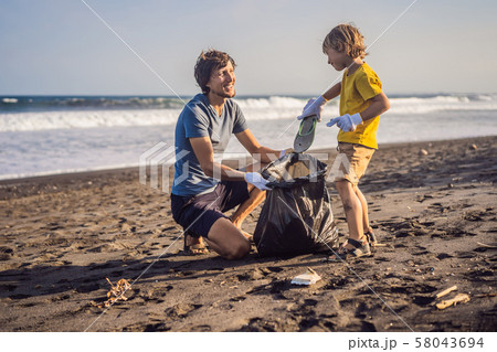 Dad and son are cleaning up the beach. Natural education of children 58043694