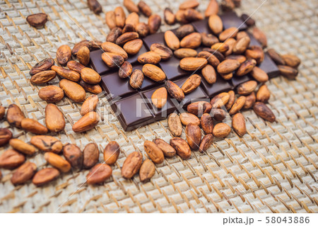 Chocolate and cocoa beans on a straw background 58043886