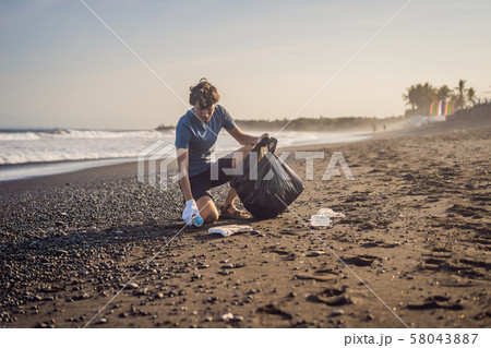 Young man cleaning up the beach. Natural education of children Young man cleaning up the beach. Natural education of children 58043887