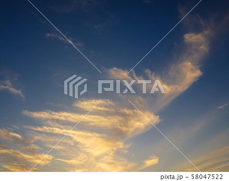 立ち上る龍雲 龍神雲 青空と夕日に照らされて輝く雲の写真素材