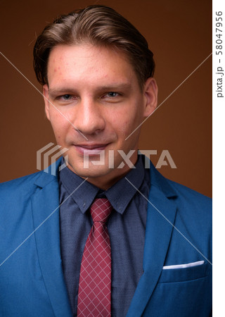 Studio shot of businessman against brown background Studio shot of businessman against brown background 58047956