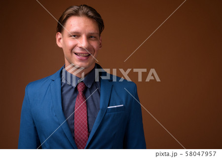 Studio shot of businessman against brown background Studio shot of businessman against brown background 58047957
