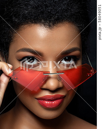 Young beautiful black woman wearing red sunglasses 58049051