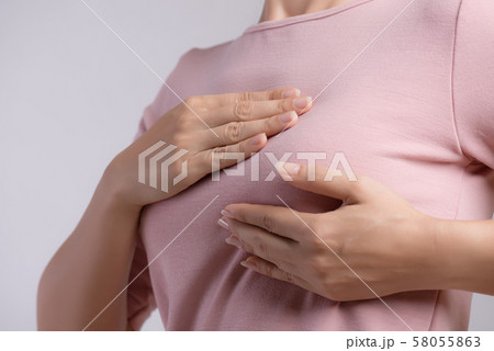 Woman hand checking lumps on her breast cancer Woman hand checking lumps on her breast cancer 58055863