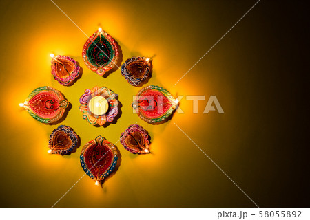 Happy Diwali - Clay Diya lamps lit, Hindu festival of lights celebration. 58055892
