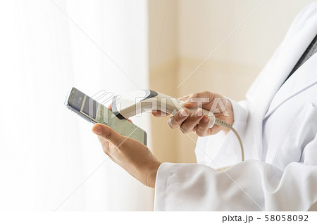 キャッシュレス決済でバーコードをスキャンする女性薬剤師 58058092