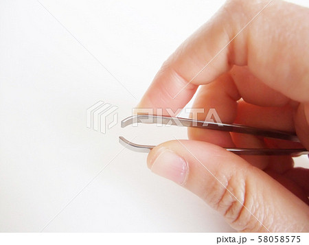 手に持った毛抜き 58058575