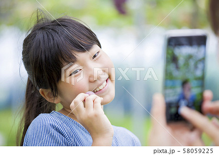 ぶどう狩りイメージ ぶどうを持った子供を撮影する母親 ぶどう狩りイメージ ぶどうを持った子供を撮影する母親 58059225