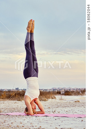 Woman doing headstand 58062044