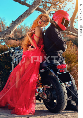 Woman and man sitting on motorcycle Woman and man sitting on motorcycle 58062419