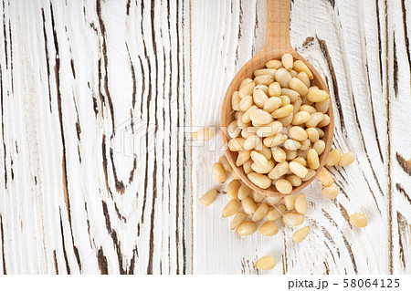 cedar nuts in spoon 58064125