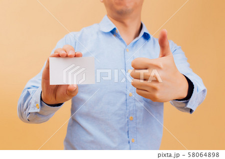 Businessman hand showing empty white business card and giving thumbs up in yellow background Businessman hand showing empty white business card and giving thumbs up in yellow background 58064898