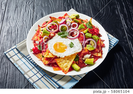 Fried tortilla chips cooked with eggs, ham Fried tortilla chips cooked with eggs, ham 58065104