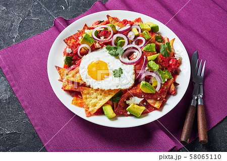nachos with a fried egg and tomato sauce 58065110