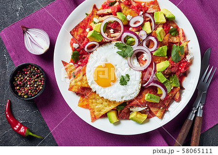 nachos with a fried sunny side up egg, ham, tomato 58065111