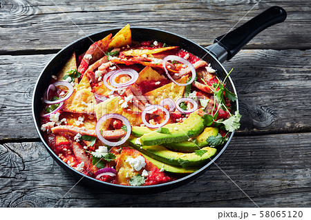 chilaquiles with ham, cheese, avocado in a skillet chilaquiles with ham, cheese, avocado in a skillet 58065120