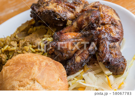Traditional Jamaican curried goat, jerk chicken and fried dumpling with rice and peas Traditional Jamaican curried goat, jerk chicken and fried dumpling with rice and peas 58067783