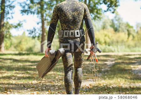 diver in wet suit and flippers with harpoon shotgun get ready for water hunting fishing 58068046