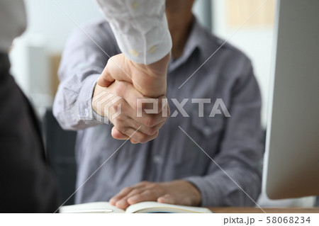 Two busineesman hand shake against office 58068234