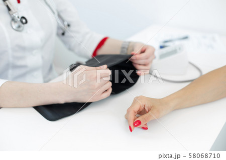 Physiotherapist puts on a medical tonometer to Physiotherapist puts on a medical tonometer to 58068710