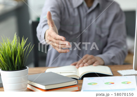 Man in gray shirt give hand as hello in office 58070150