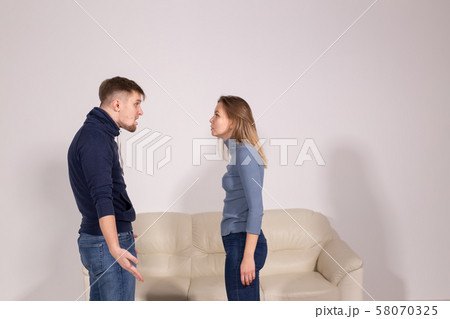 people, home violence and abuse concept - young couple screaming to each other people, home violence and abuse concept - young couple screaming to each other 58070325