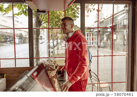 Cheerful sportsman ordering food in a coffee shop Cheerful sportsman ordering food in a coffee shop 58070461