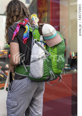 Unrecognizable tourist with a backpack standing near the showcase of shop souvenirs, travel and 58070865