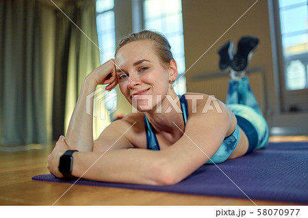 Beautiful portrait of young woman relaxing form exercise and smiling during a break in the gym 58070977