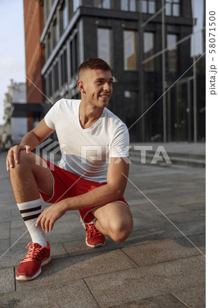 Pleased sportive man looking into the distance 58071500
