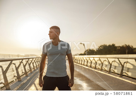 Attractive serious muscular young man looking away 58071861