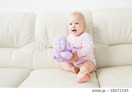 Child, childhood and kids concept - beautiful smiling baby sitting Child, childhood and kids concept - beautiful smiling baby sitting 58072595